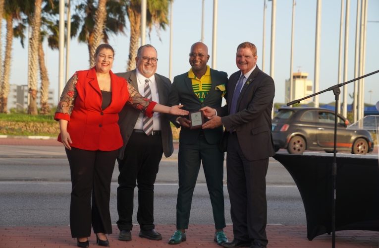 Riba Dia di Independencia di Jamaica, a hisa e bandera Jamaiquino pa prome bes na rotonde di Aeropuerto Internacional Reina Beatrix